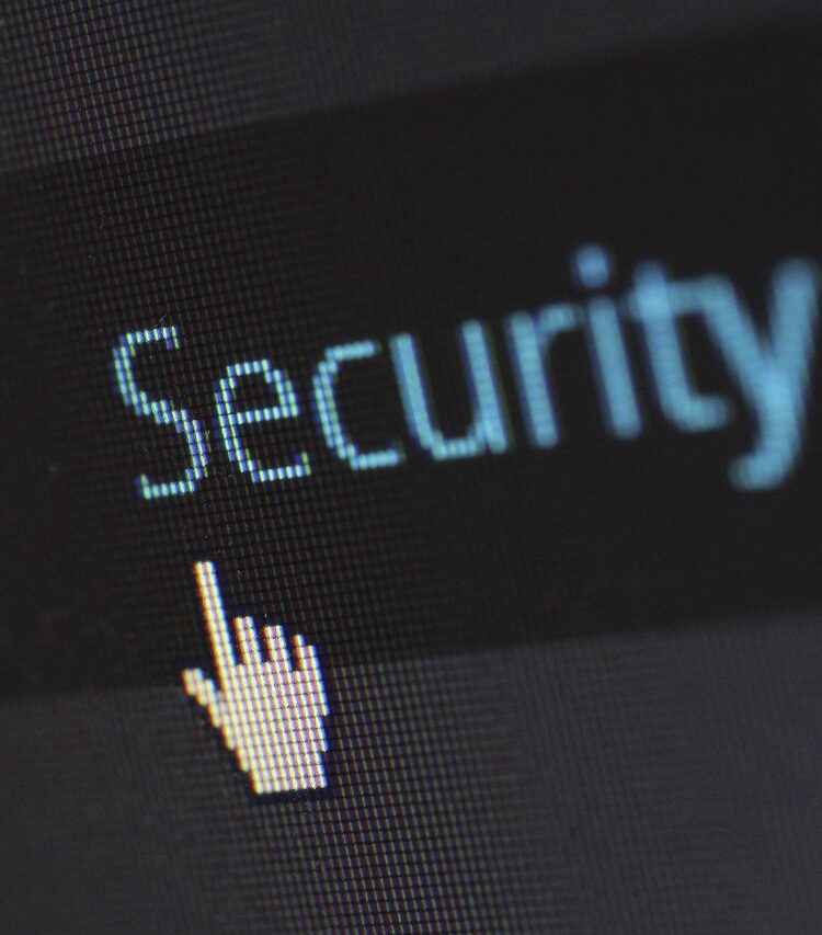Nahaufnahme eines Computerbildschirms mit dem Wort 'Security' und einer klickenden Mauszeiger-Hand – Symbol für Cybersicherheit und Datenschutz.